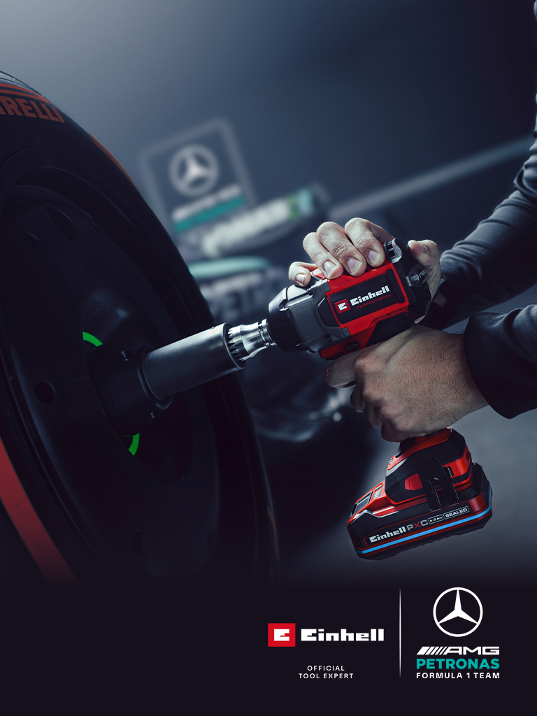 Einhell accu slagschroevendraaier in gebruik op een autowiel, met Mercedes-AMG Petronas Formula One Team-branding en partnerlogo