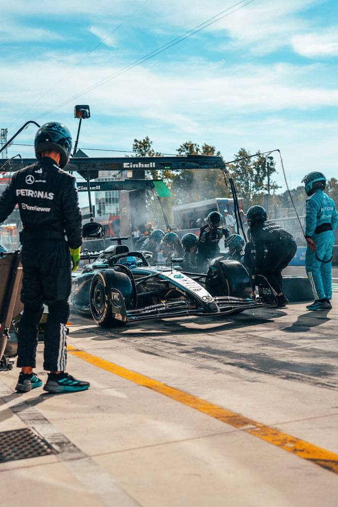 Een intensieve pitstop voor het Mercedes-AMG PETRONAS Formula One Team. Het team is in actie, wisselt banden en controleert de auto onder de Einhell-gemerkte portaalconstructie.