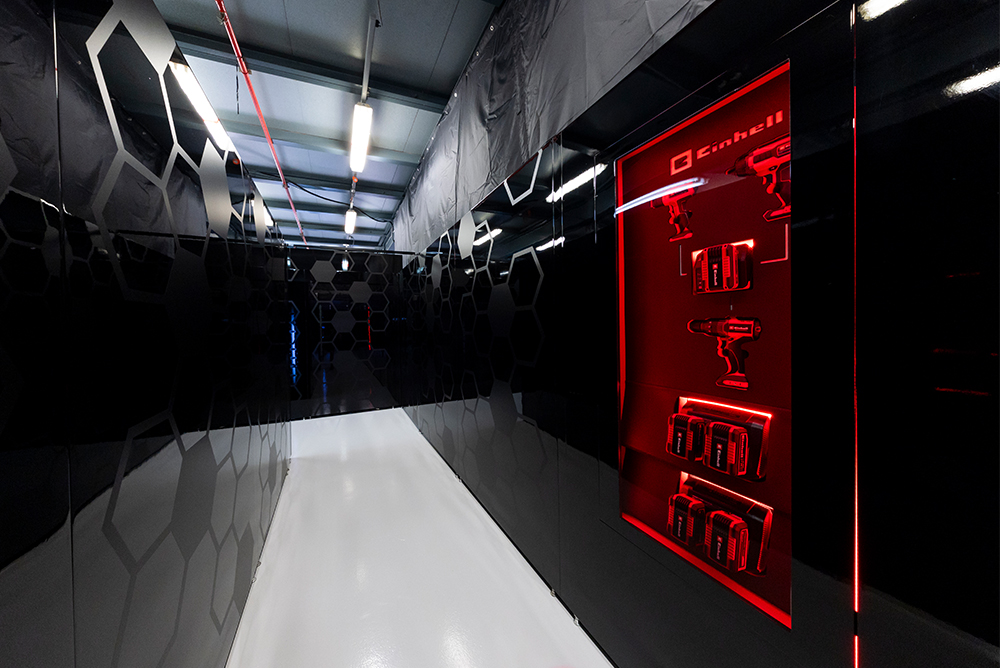 Gang in de Formule 1-garage in de pitstraat met rode verlichting.