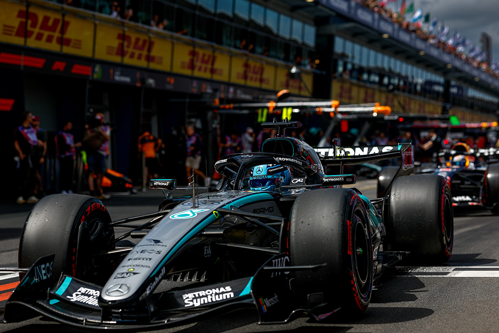 Formule 1-auto in de pitstraat omringd door het team voor de start.
