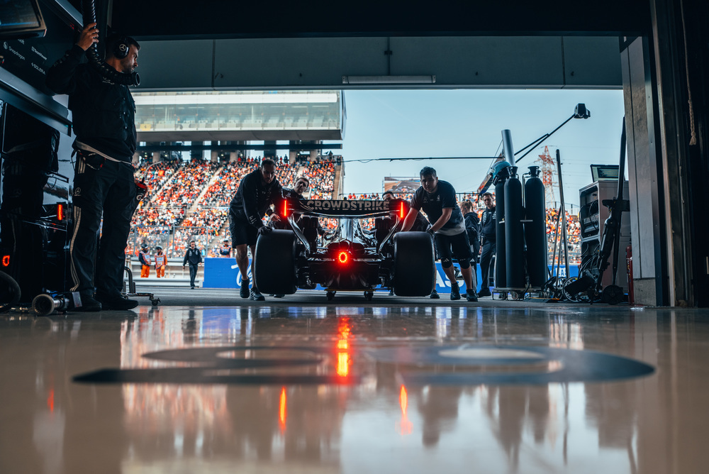Mercedes F1-auto in de garage met apparatuur en verlichting
